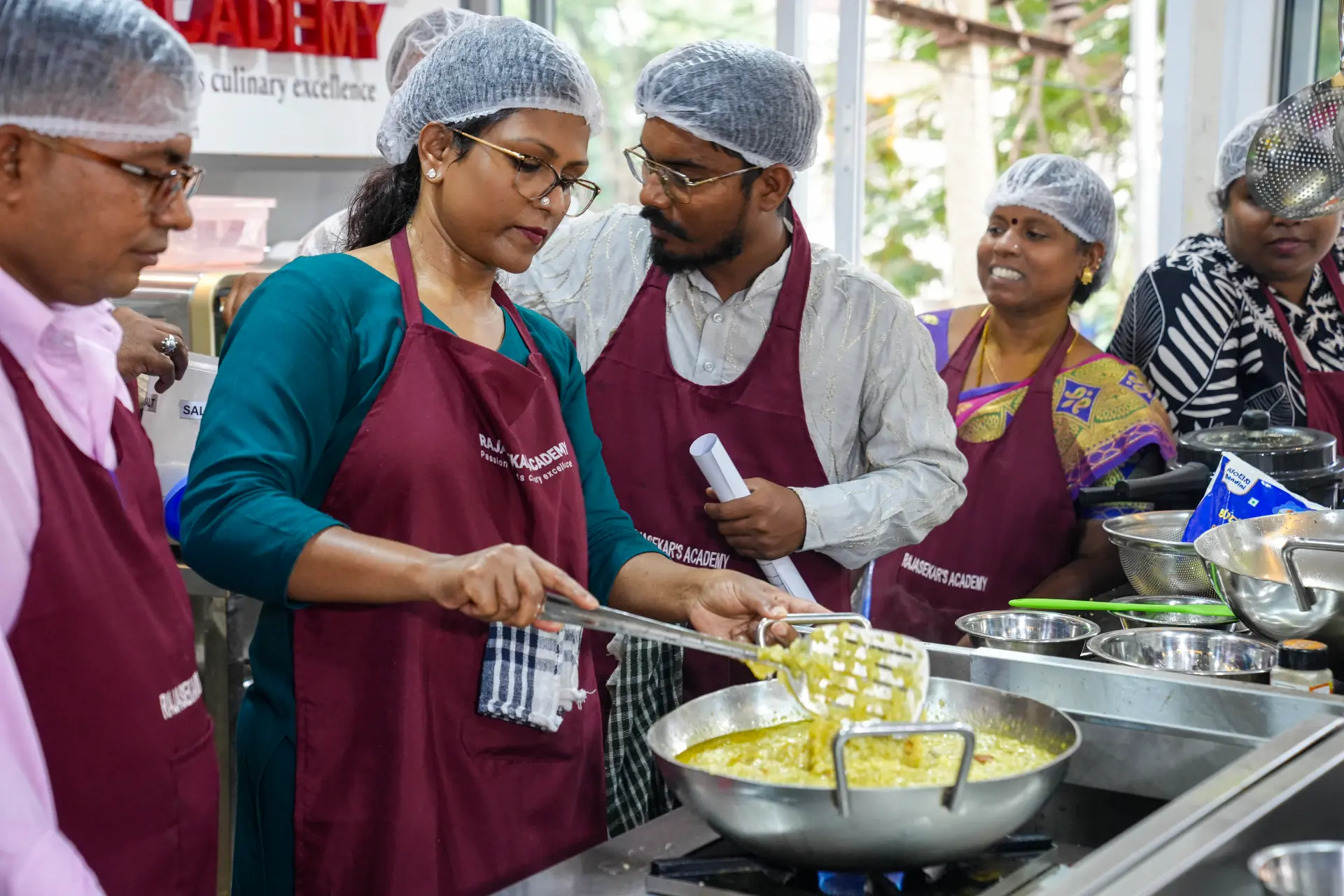 Chef Rajasekar guiding students during a hands-on cooking session