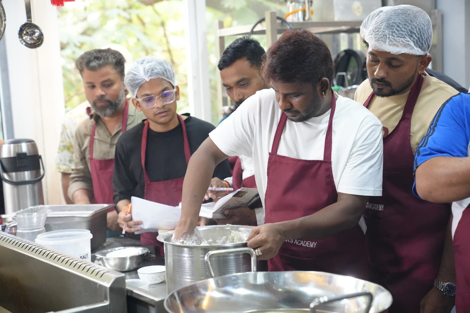 Chef Rajasekar and students working together in the academy kitchen